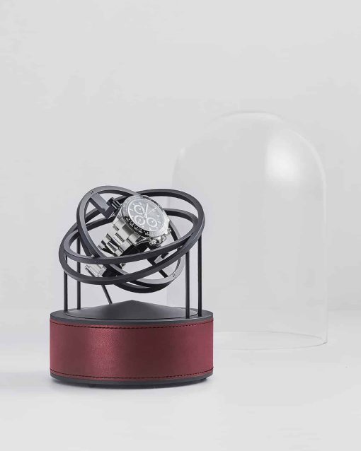 Bilde av Bernard Favre Planet Winder med sort base i aluminium, rødt skinn og sorte ringer.